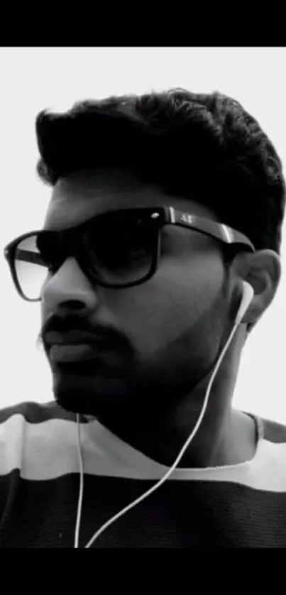 Monochrome portrait of person in sunglasses with earphones, black and white style.