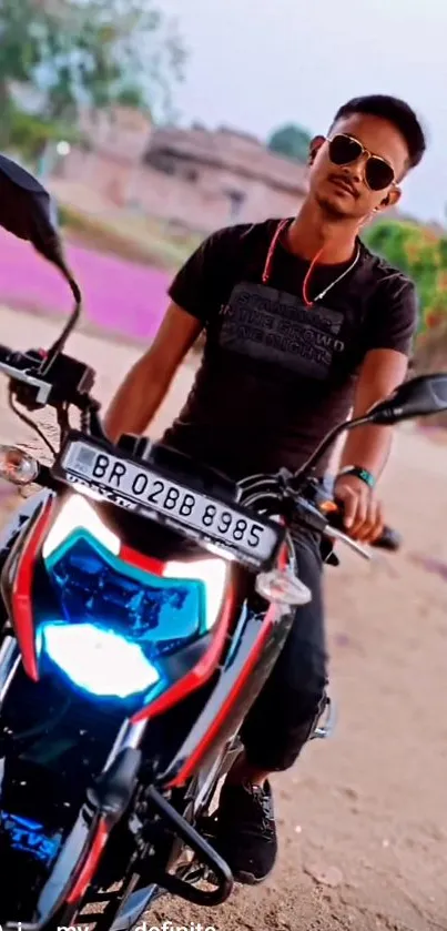 Person posing with motorcycle in scenic outdoor setting.