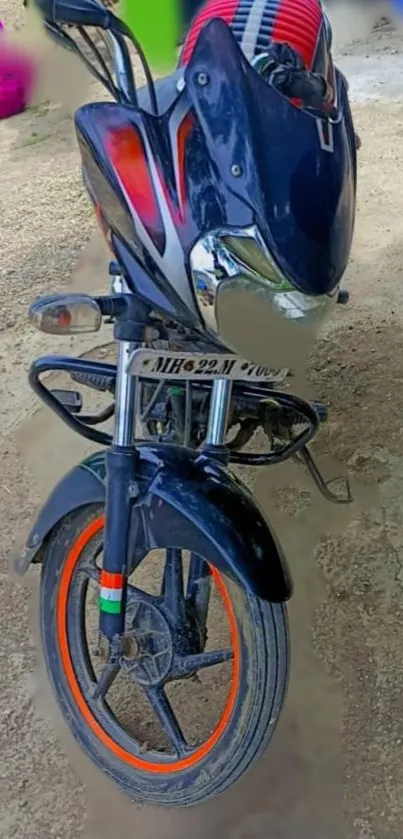 A sleek motorcycle with vibrant wheels on an outdoor path.