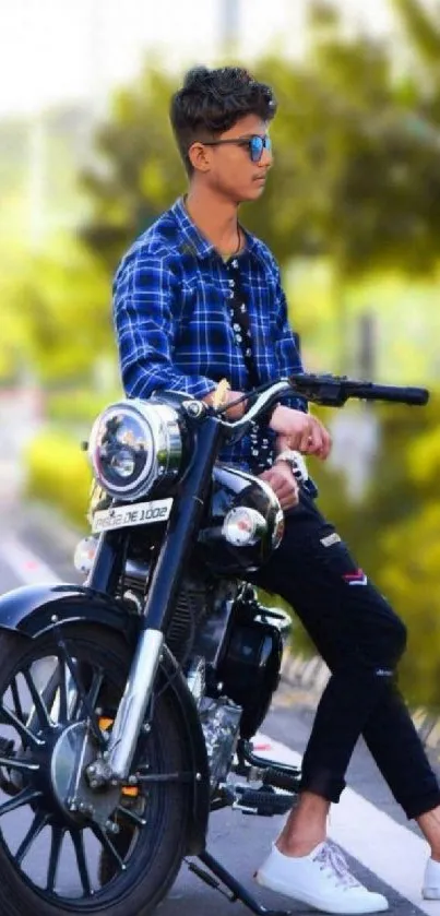 Man in sunglasses sits on a motorcycle by a scenic urban street.