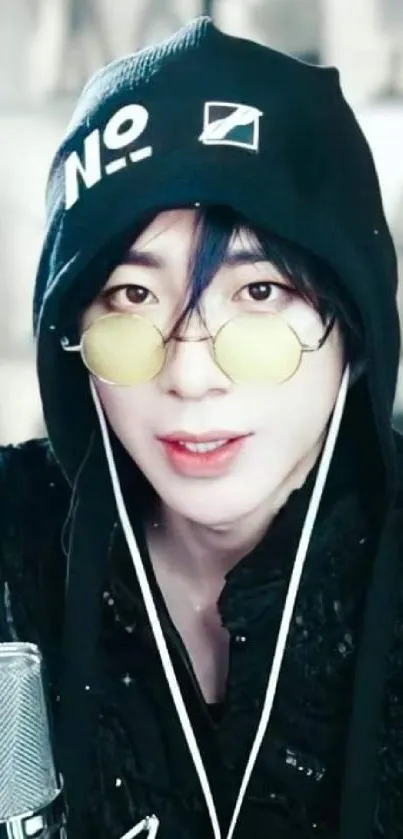 Stylish music artist with glasses and black hoodie.