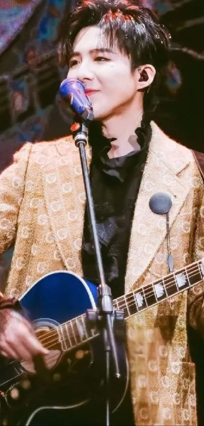 Musician in brown jacket playing guitar on stage with vibrant lights.