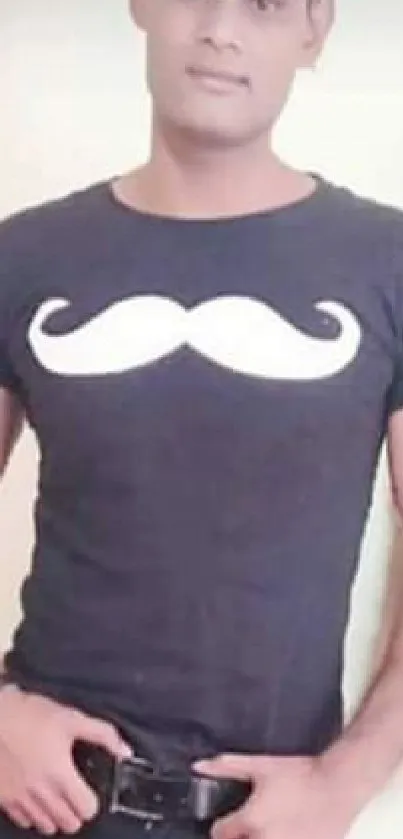 Man in black mustache T-shirt posing confidently.