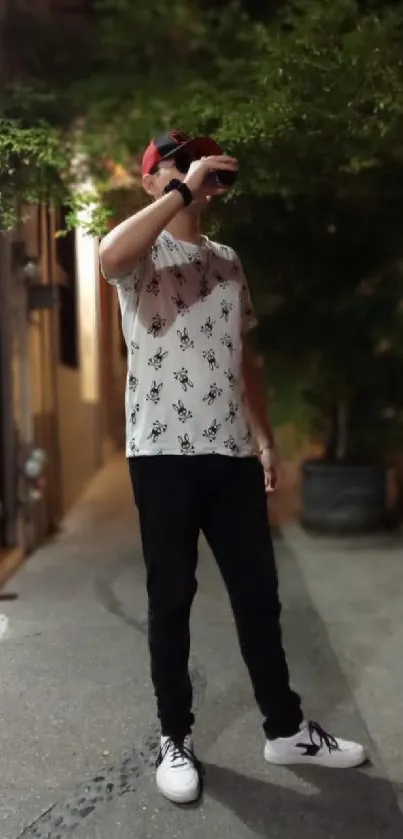 Man on street wearing patterned shirt at night.