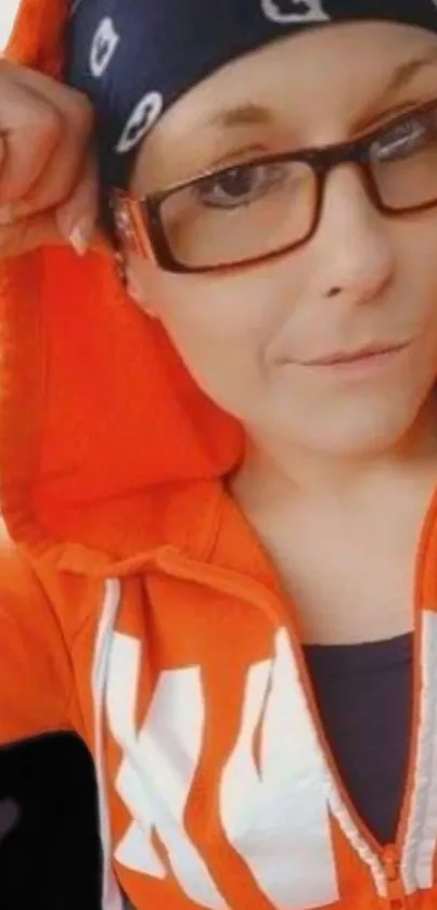 Person in an orange hoodie with glasses.