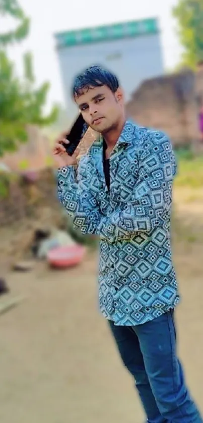 Man talking on phone in outdoor setting, wearing a patterned shirt.