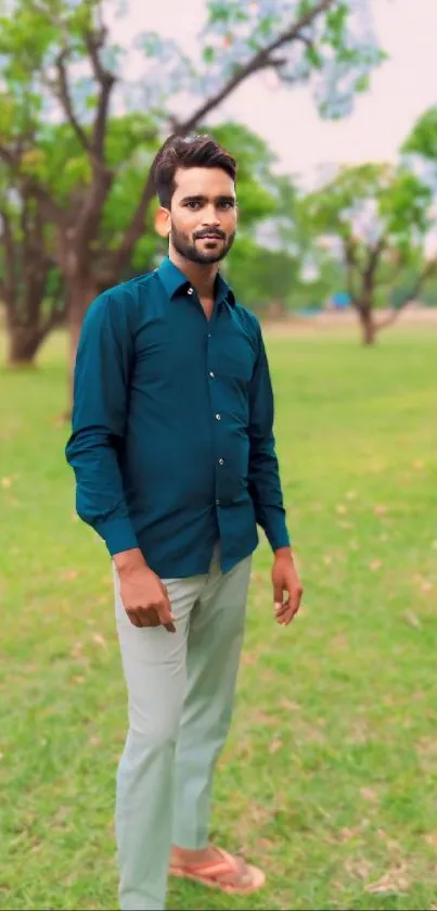 Person posing stylishly in a green park setting.