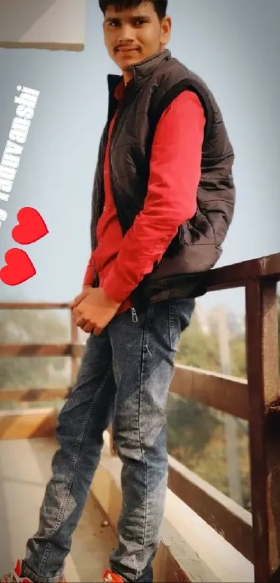 Man in casual attire posing on a balcony.