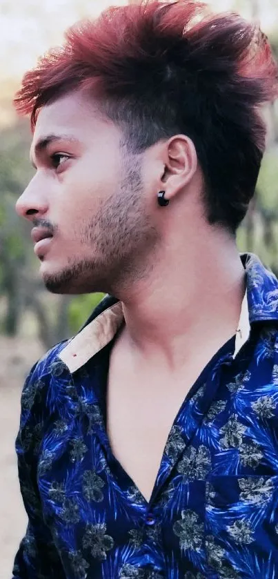 Side profile of a stylish man outdoors with a blurred nature background.