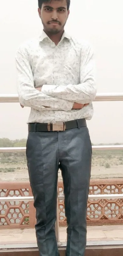 Stylish young man posing outdoors with scenic background.