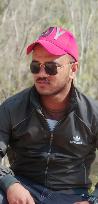 Person with pink cap and sunglasses in nature.