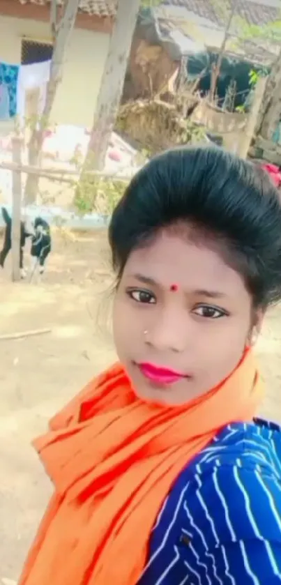 Outdoor portrait of a young woman with colorful scarf in a rural setting.