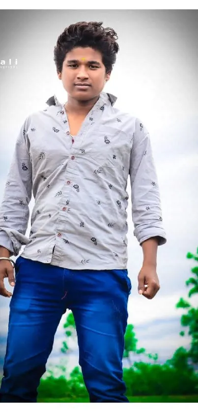 Young man in stylish shirt with blue pants outdoors.