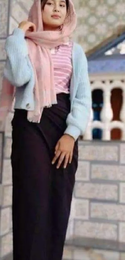 Woman in a pastel pink and blue outfit, posing gracefully.