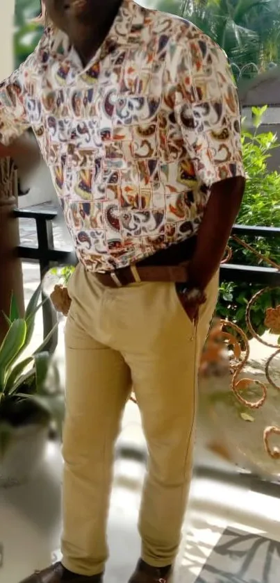 Man in vibrant shirt and khaki pants on a patio.