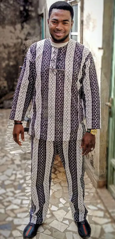 Stylish man in patterned outfit standing outdoors.