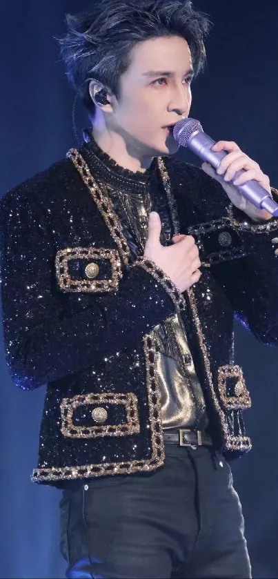 Stylish performer in black and gold outfit singing on stage.