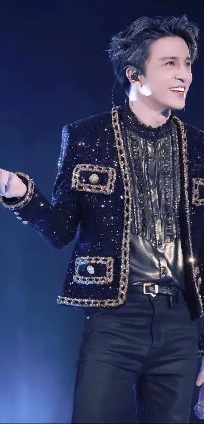 Performer in a sparkling black jacket on stage.