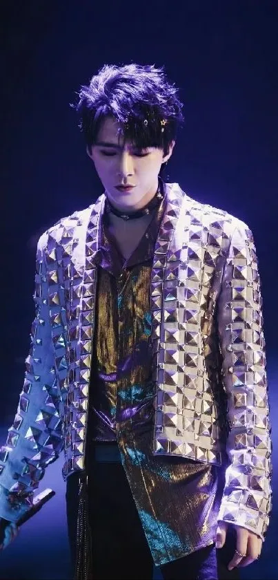 Performer in metallic jacket on dark stage wallpaper.