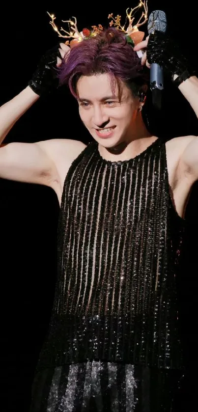 Performer wearing antler headpiece on stage.