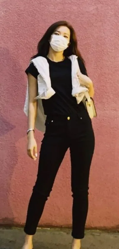 Fashionable figure in front of a pink wall.