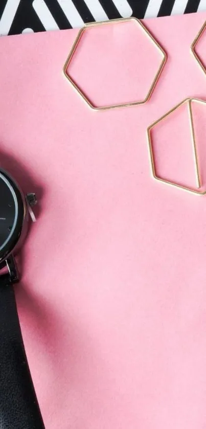 Minimalist pink wallpaper with black watch and geometric shapes.