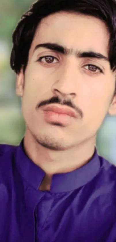 Blue shirt portrait with blurred natural background.