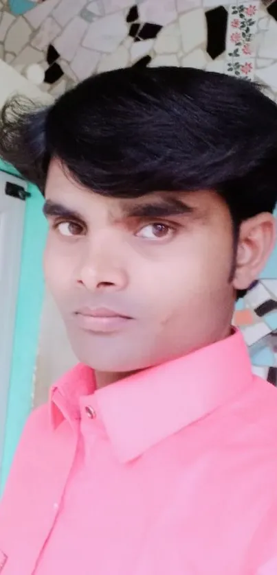 Portrait of a person in a pink shirt with tiled background.