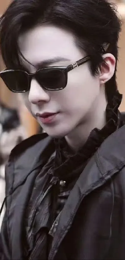 Person wearing sunglasses and a stylish black jacket.