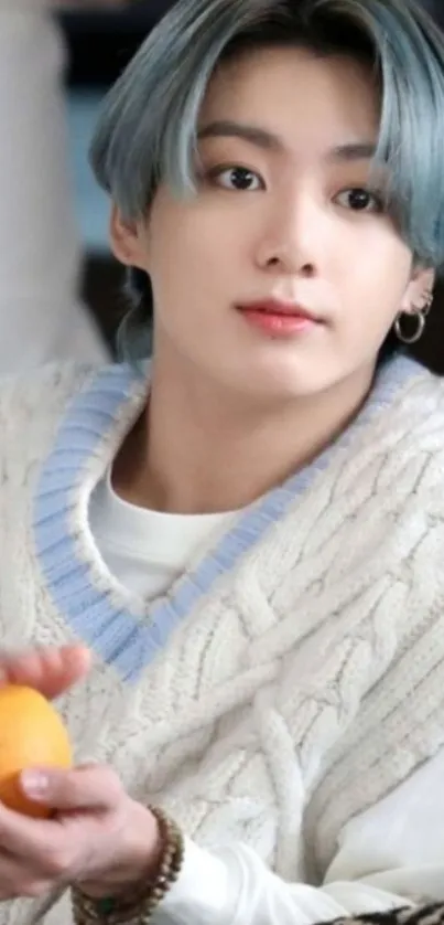 Stylish person with blue-gray hair in a cozy sweater.