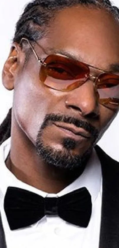 Stylish man with sunglasses and tuxedo on white background.