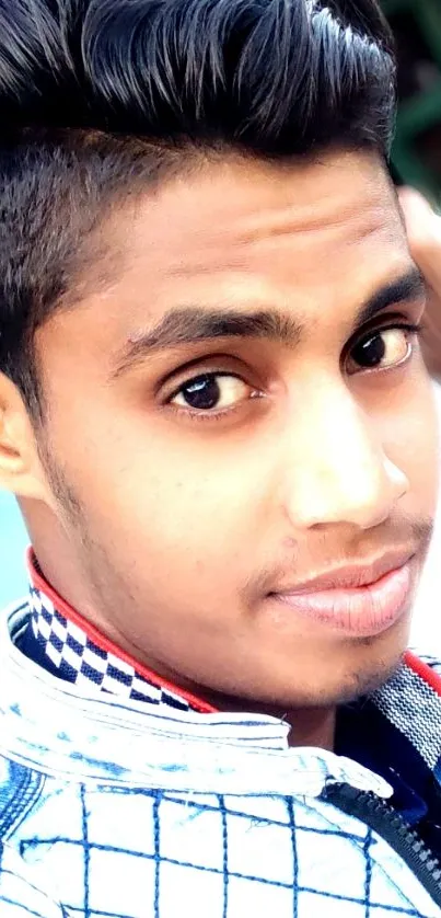 Stylish young man portrait with a modern hairstyle on a light blue background.