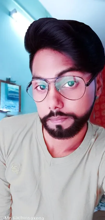 Portrait of a bearded man with glasses in a colorful room setting.