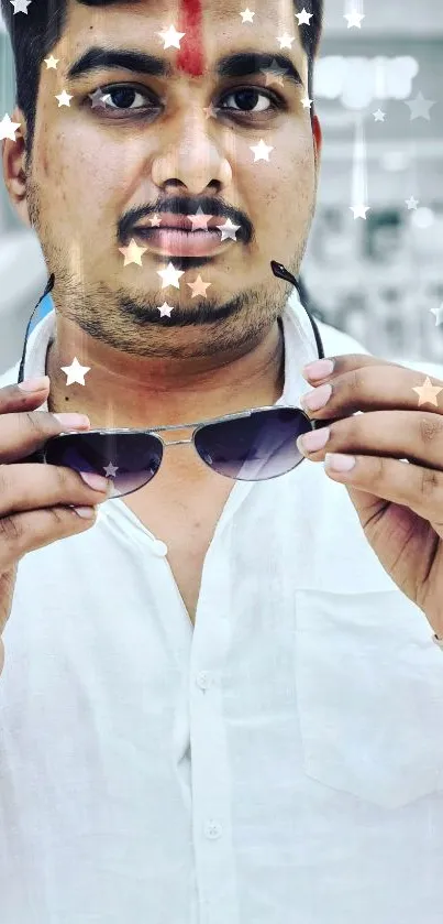 Stylish man holding sunglasses with star overlay.