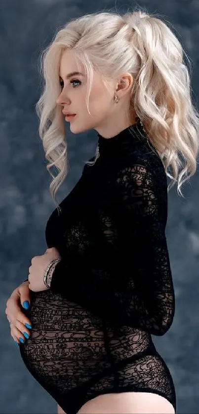 Elegant portrait of pregnant woman in black lace against gray background.