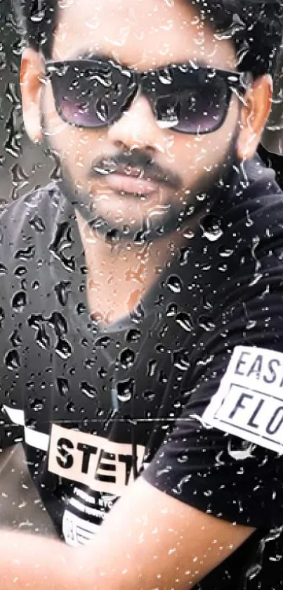 Portrait of a man in sunglasses, viewed through raindrop-covered glass.