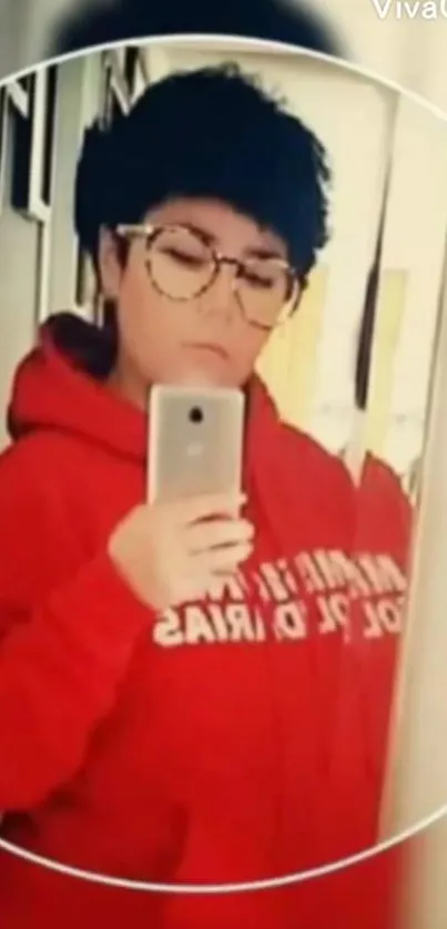 Person in red hoodie taking a mirror selfie.