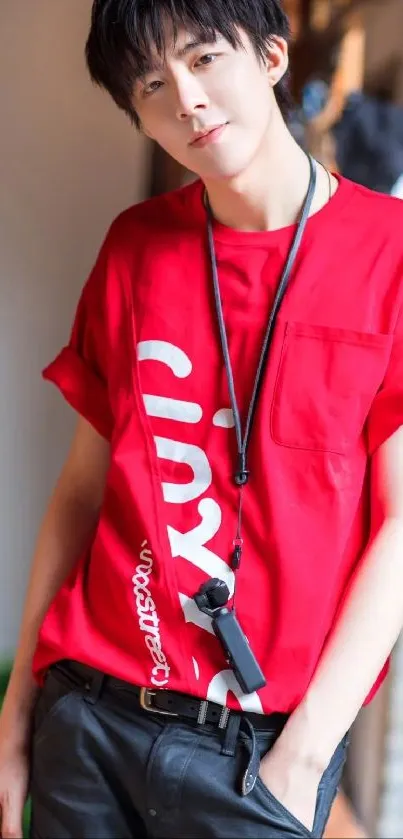 Person in a vibrant red shirt leaning against a wall.