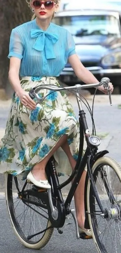 Woman in floral skirt and blue blouse riding a vintage bicycle.