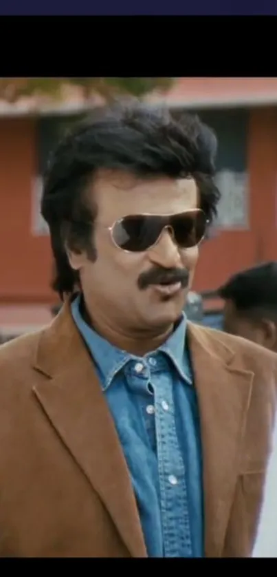 Stylish man in sunglasses and brown jacket outdoors.