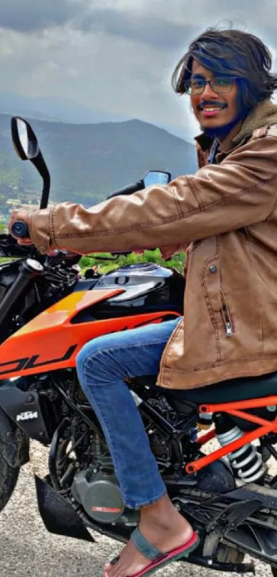 Stylish rider on an orange motorcycle with a mountainous backdrop.