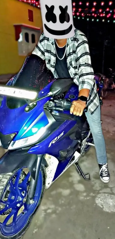 Person wearing mask on a blue sports bike with colorful lights in background.