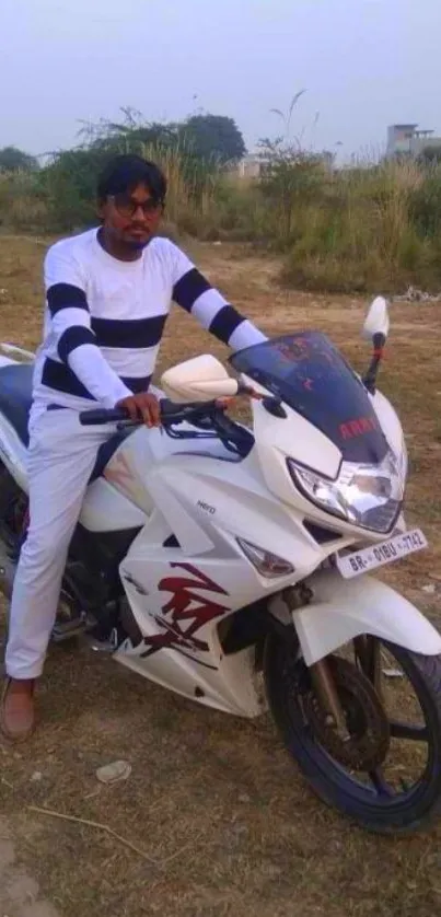 A man in stylish attire poses on a white motorcycle.