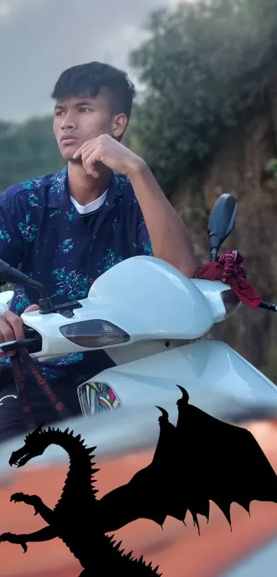 Young man on motorbike with dragon silhouette.