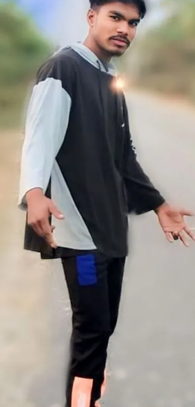 Young man in stylish roadside pose with casual outfit.