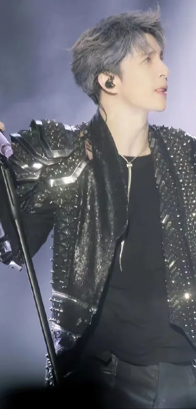 Stylish rockstar in black leather jacket on stage.