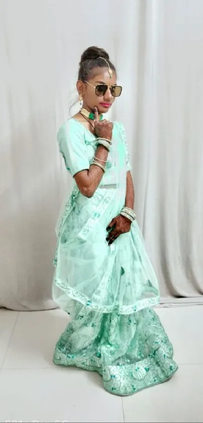 Young woman posing in mint green saree, stylish and elegant.