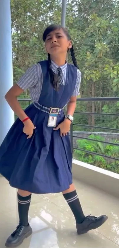 Student in school uniform posing outdoors with a green nature backdrop.