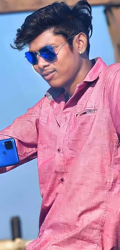 Person taking a selfie in a stylish pose with blue and pink attire.