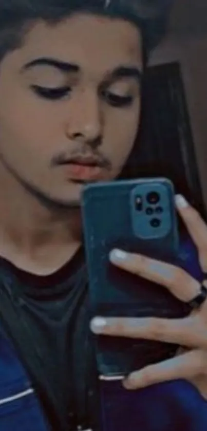 Stylish young individual taking a selfie with a mobile phone, dark blue hues.